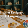A stylish modern living room with an orange sofa, wooden coffee table, potted plant, and sideboard, featuring vertical wooden fluted panels on the wall behind the sofa. White text reading "Interior Designers In Gurgaon" is prominently displayed on the wall.